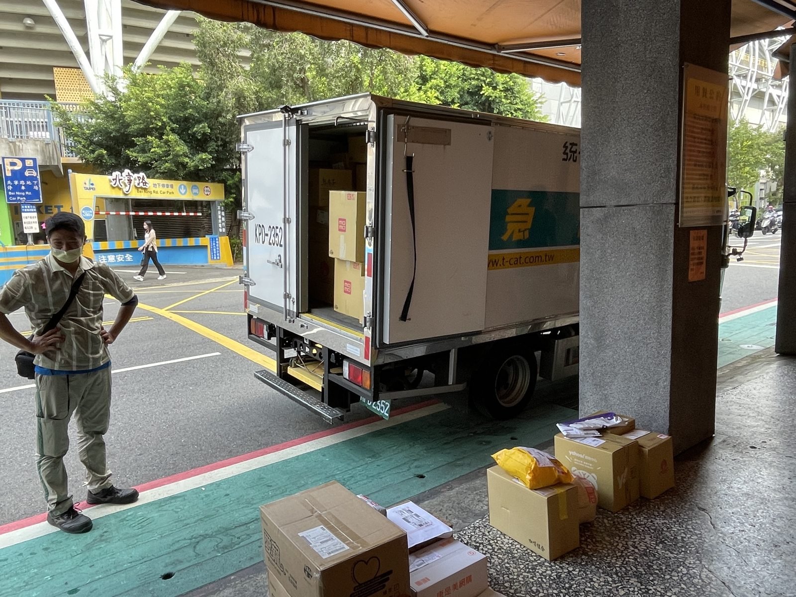 Courier sorting parcels beside the delivery truck